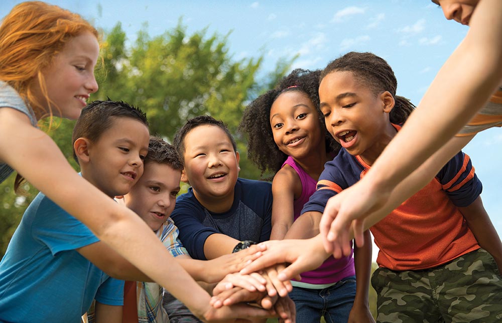 Group of kids put their hands together