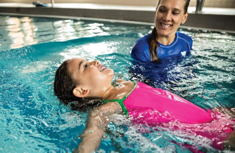 Swim instructor guides her student